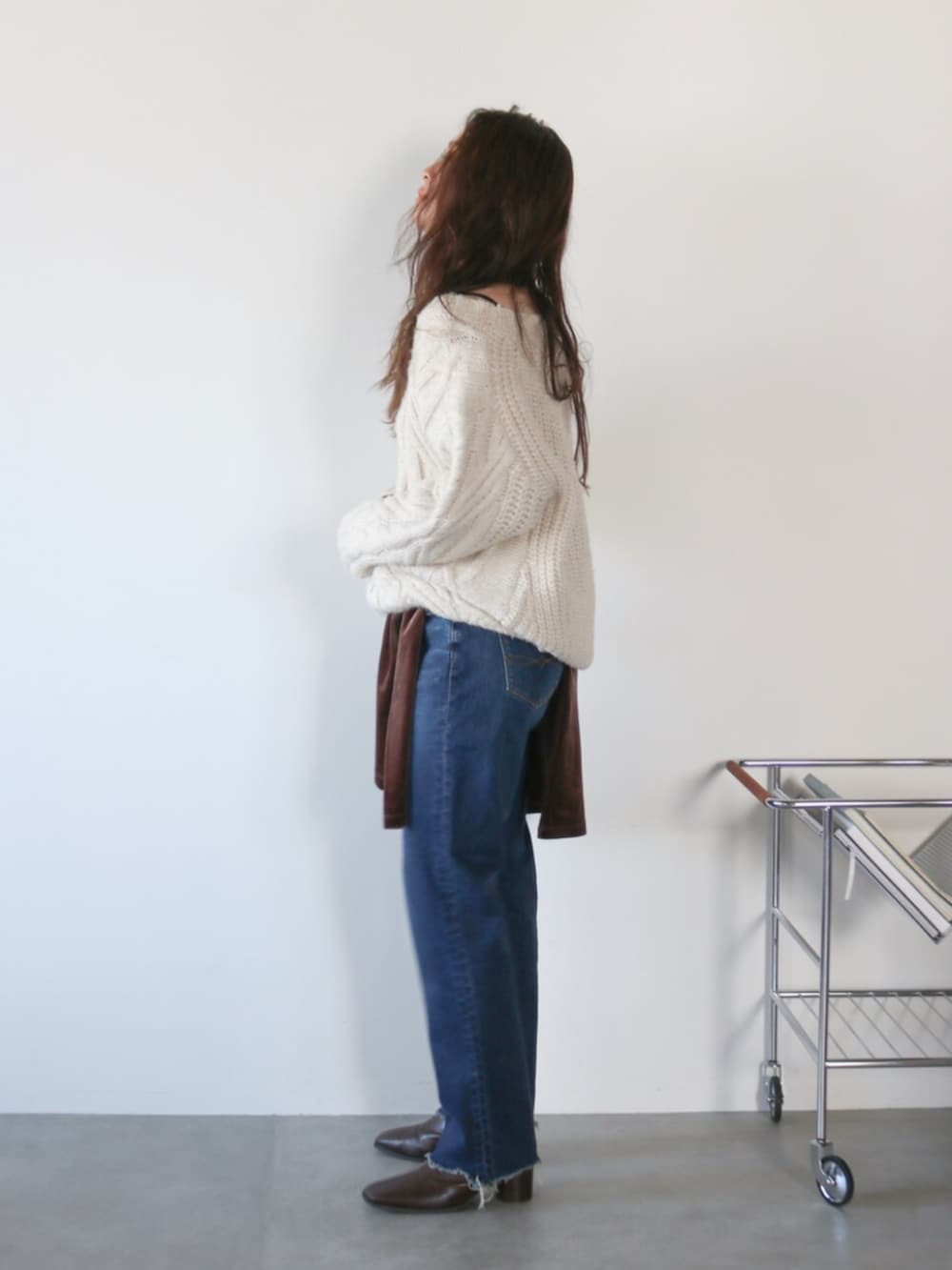 ホワイト系のニット/セーター、ブラウン系のシャツ/ブラウス、ブルー系のデニムパンツを着用したレディースの秋コーディネートの2枚目の写真
