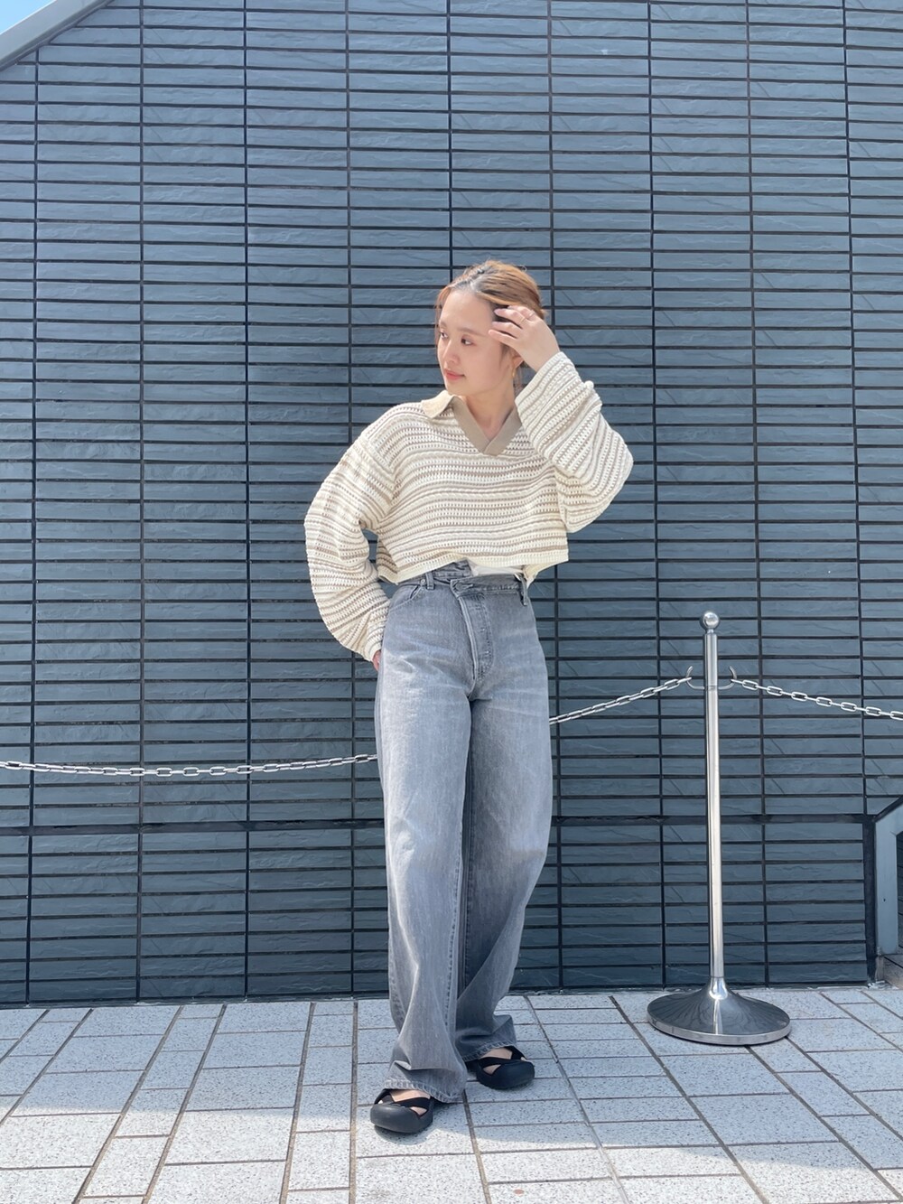 ブラック系のデニムパンツ、ベージュ系のニット/セーターを着用したレディースの春コーディネートの5枚目の写真