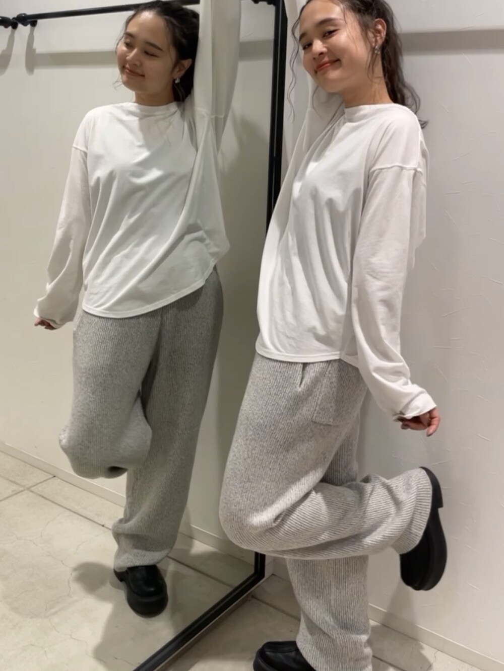 ブルー系のニット/セーター、ブルー系のデニムパンツ、ブラック系のブーツを着用したレディースの秋コーディネートの2枚目の写真