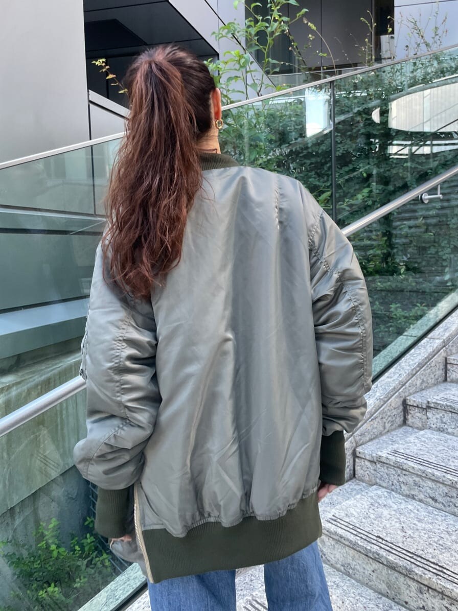 ブルー系のデニムパンツ、ブラック系のブーツ、グリーン系のMA-1を着用したレディースの秋コーディネートの5枚目の写真