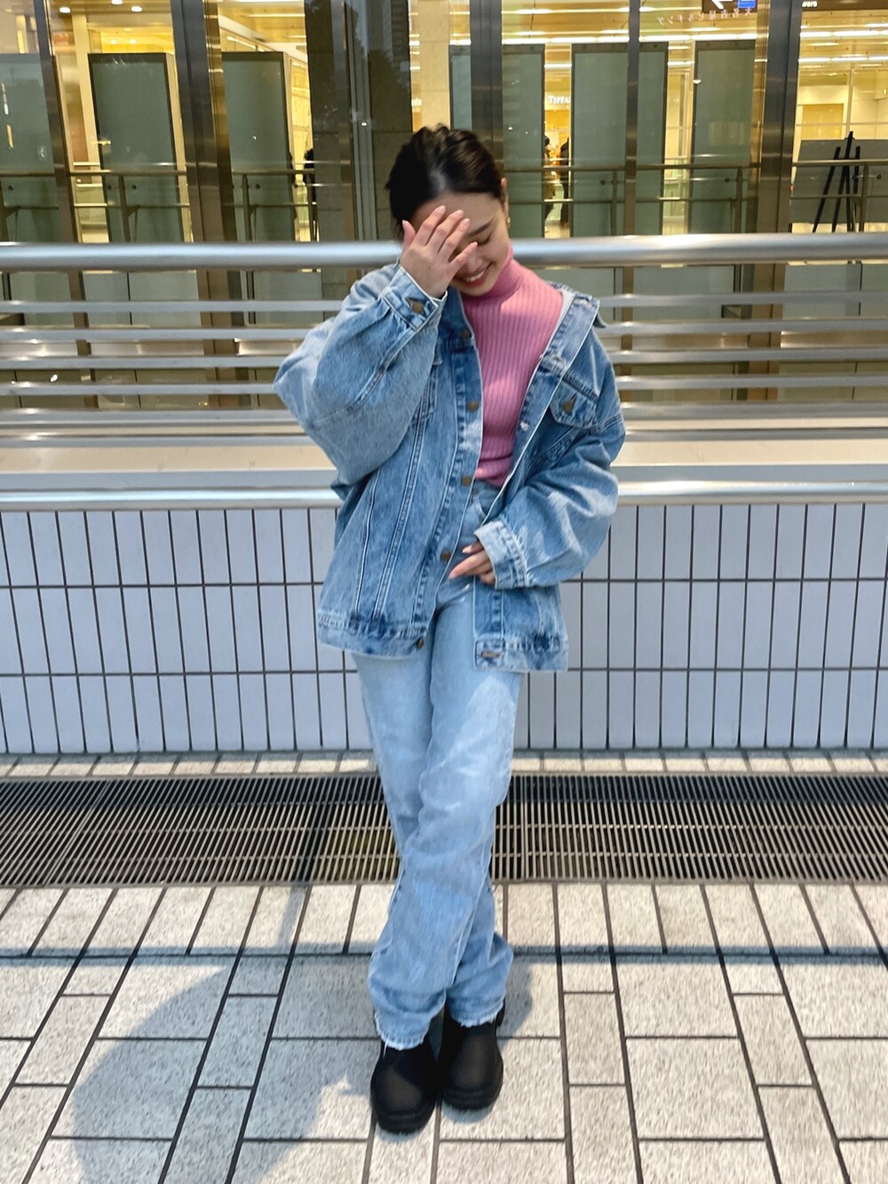 ブルー系のデニムジャケット、ピンク系のニット/セーター、ブルー系のデニムパンツを着用したレディースの冬コーディネートの4枚目の写真