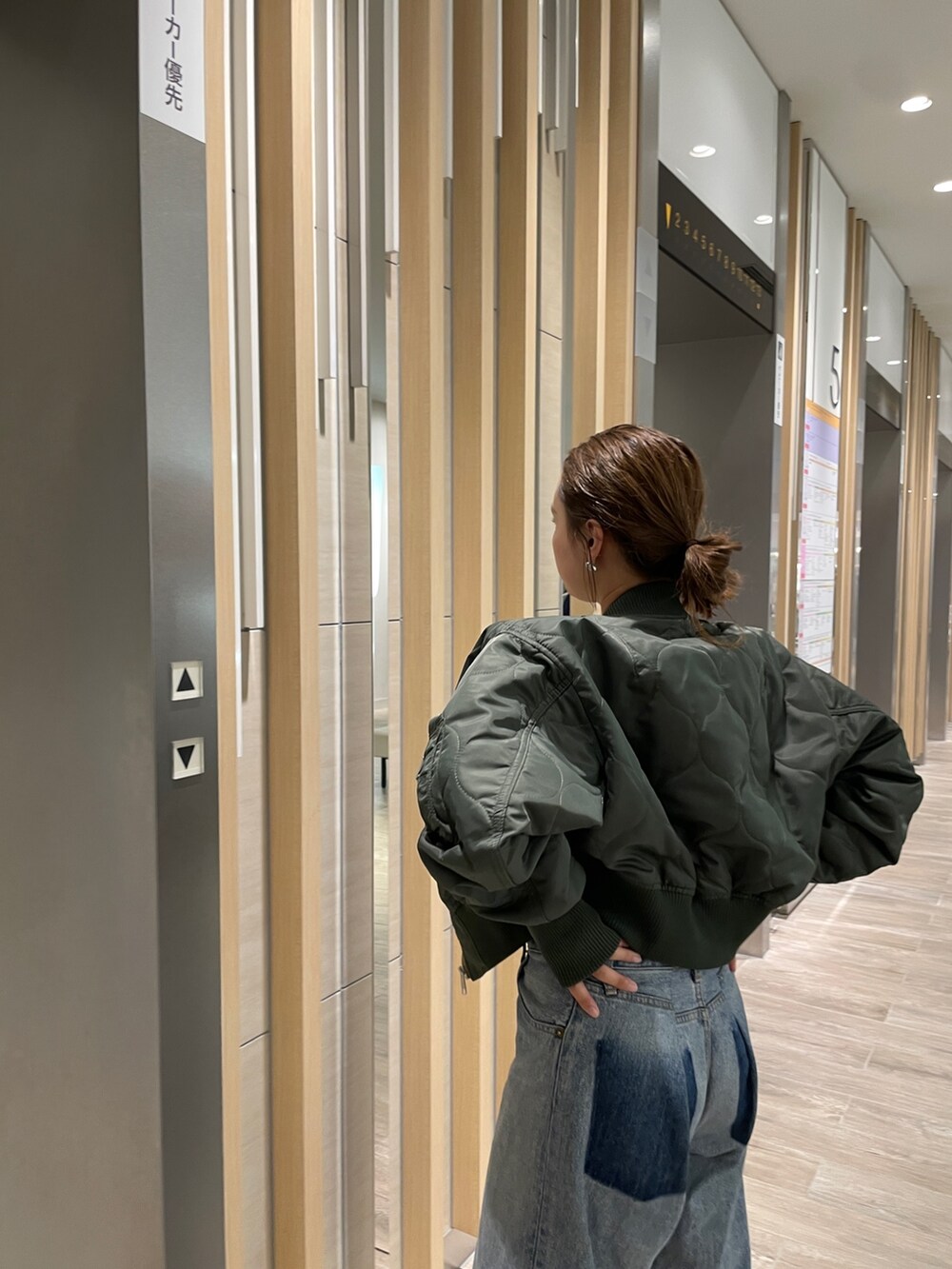 ブルー系のデニムパンツ、シルバー系のパンプス、ベージュ系のブルゾンを着用したレディースの秋コーディネートの2枚目の写真