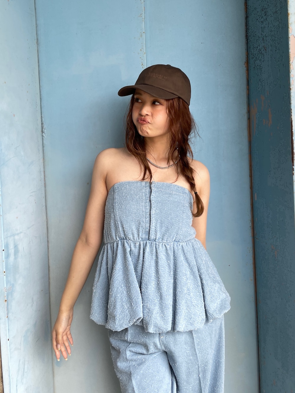 ブルー系のチューブトップ、ブルー系のデニムパンツを着用したレディースの春コーディネートの4枚目の写真