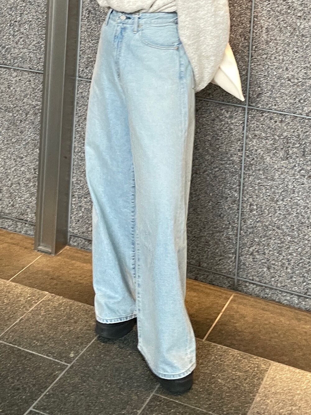 ブルー系のデニムパンツ、ホワイト系のニット/セーター、レッド系のトートバッグを着用したレディースの秋コーディネートの4枚目の写真