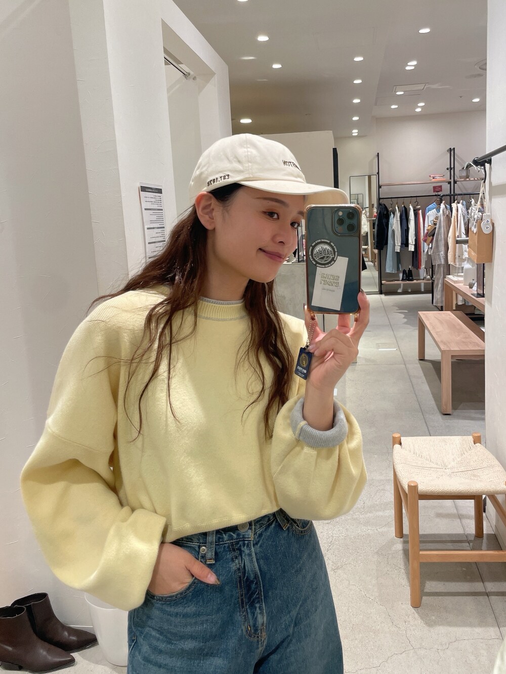 イエロー系のニット/セーター、ブルー系のデニムパンツを着用したレディースの冬コーディネートの2枚目の写真