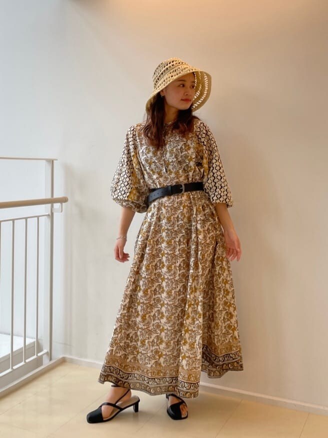 ホワイト系のワンピース、ブラック系のサンダル、ベージュ系のハットを着用したレディースの春コーディネートの3枚目の写真