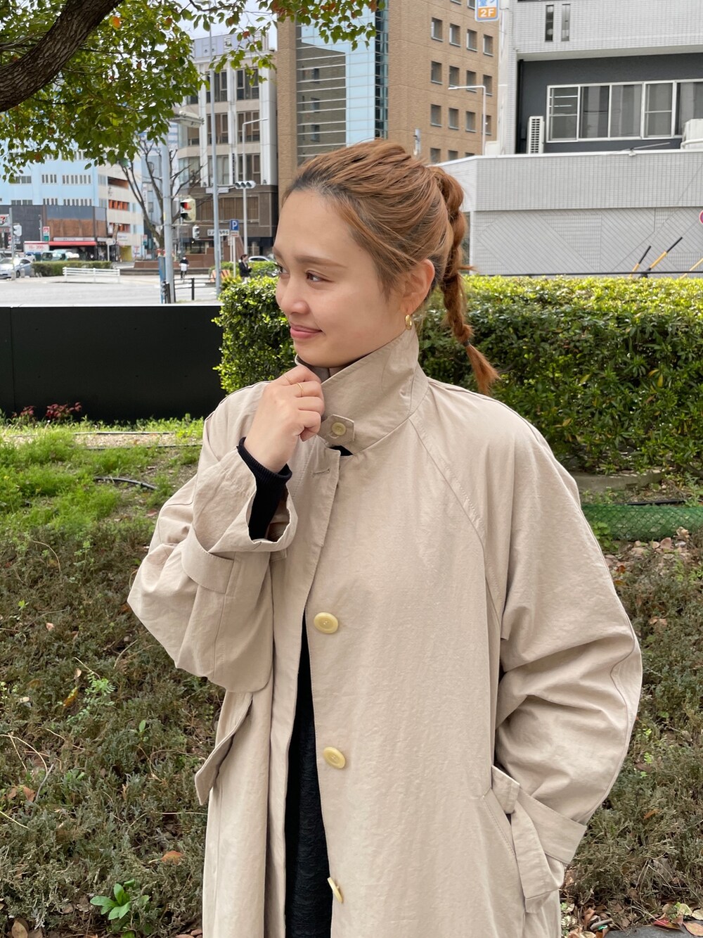 グリーン系のワンピース、ブルー系のトートバッグ、ベージュ系のステンカラーコートを着用したレディースの春コーディネートの5枚目の写真