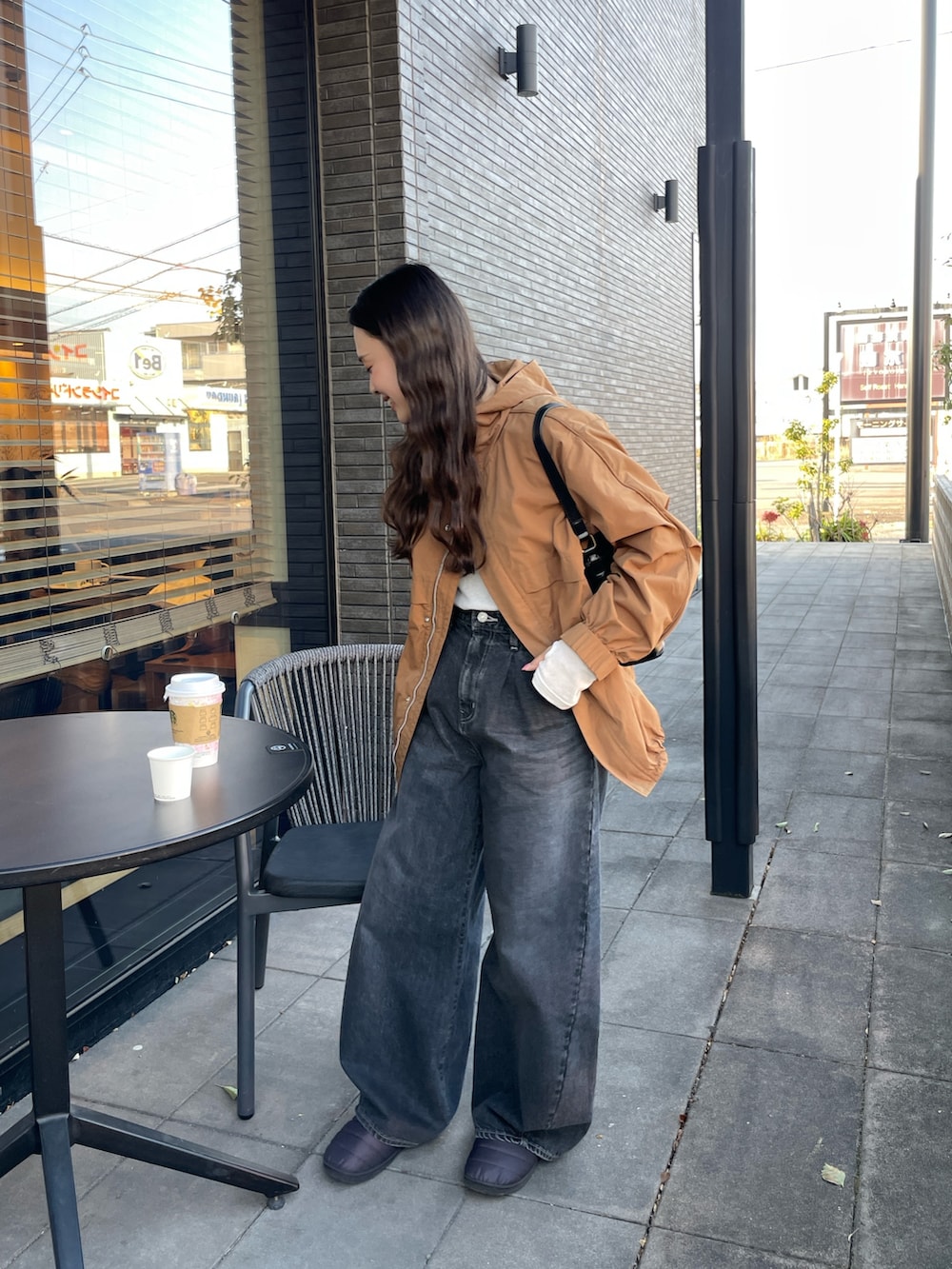 ブラック系のデニムパンツ、ベージュ系のブルゾン、ホワイト系のTシャツ/カットソーを着用したレディースの冬コーディネートの7枚目の写真