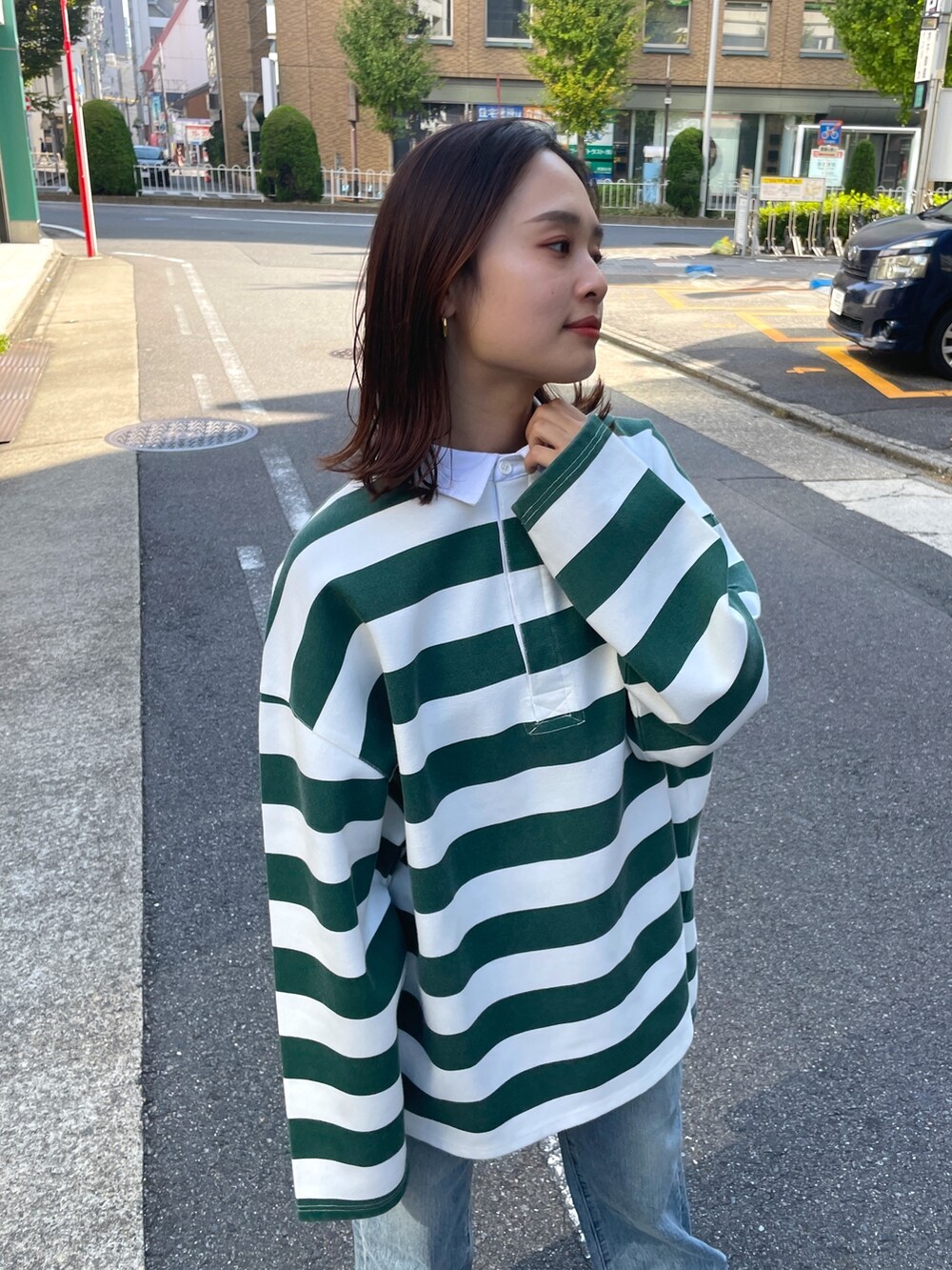 グリーン系のTシャツ/カットソー、ブルー系のデニムパンツを着用したレディースの秋コーディネートの3枚目の写真