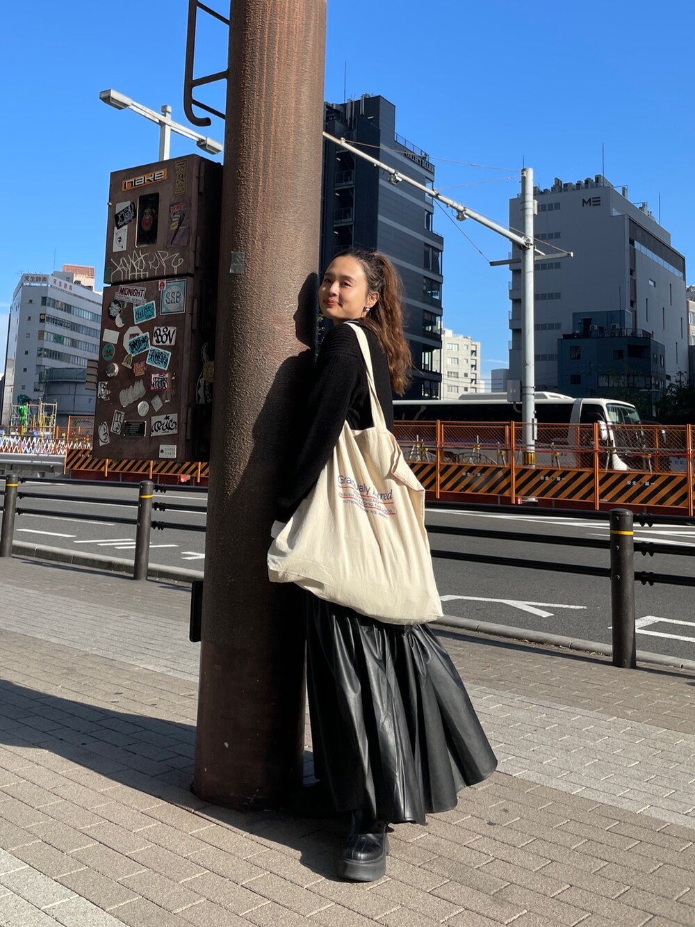 ブラック系のニット/セーター、ホワイト系のTシャツ/カットソー、ブラック系のスカートを着用したレディースの冬コーディネートの6枚目の写真