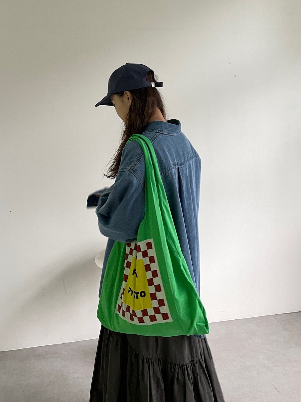 ブルー系のシャツ/ブラウス、グレー系のスカート、グリーン系のトートバッグを着用したレディースの冬コーディネートの3枚目の写真