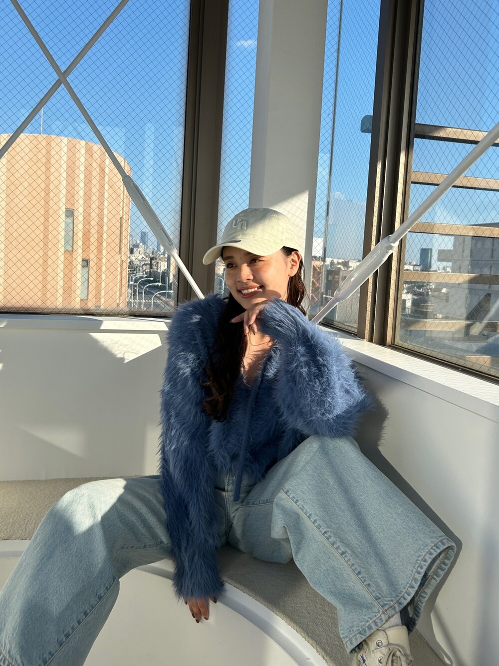 ブルー系のニット/セーター、ブルー系のデニムパンツを着用したレディースの冬コーディネートの2枚目の写真