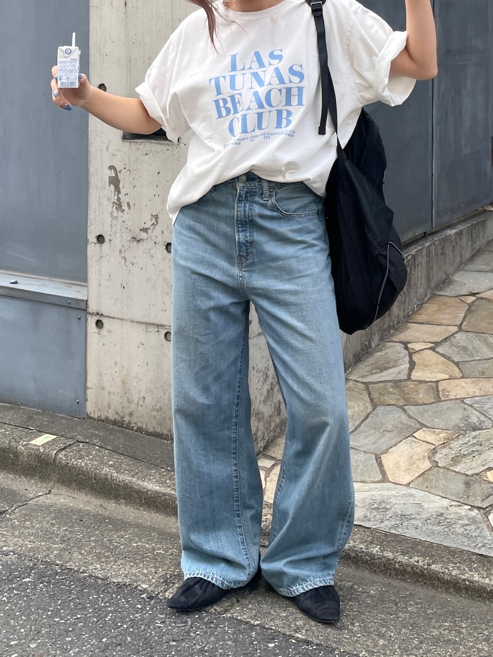 ホワイト系のTシャツ/カットソー、ブルー系のデニムパンツ、ブラック系のバックパック/リュックを着用したレディースの春コーディネートの2枚目の写真
