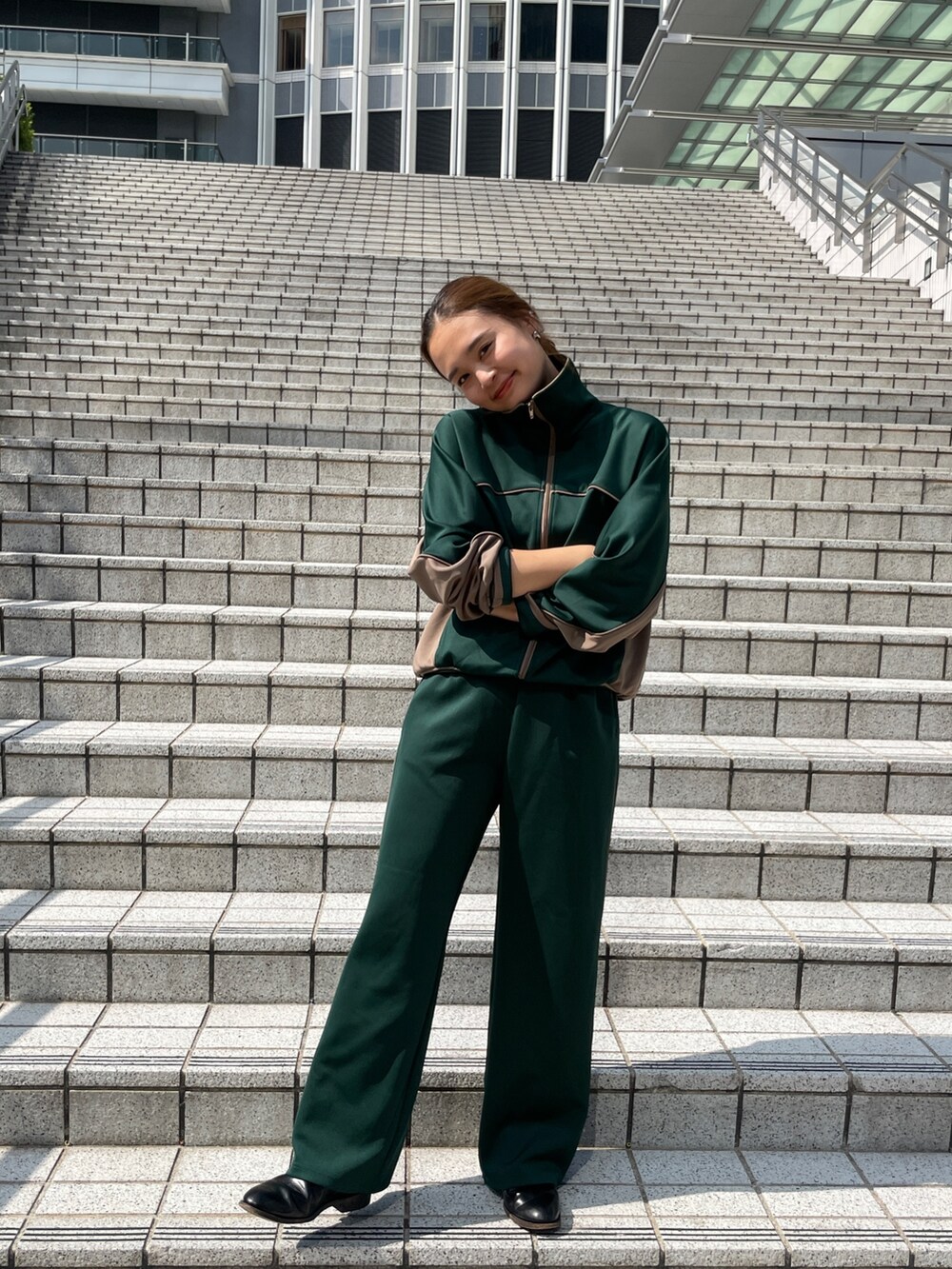 グリーン系のブルゾン、グリーン系のその他パンツ、ホワイト系のダウンベストを着用したレディースの秋コーディネートの8枚目の写真