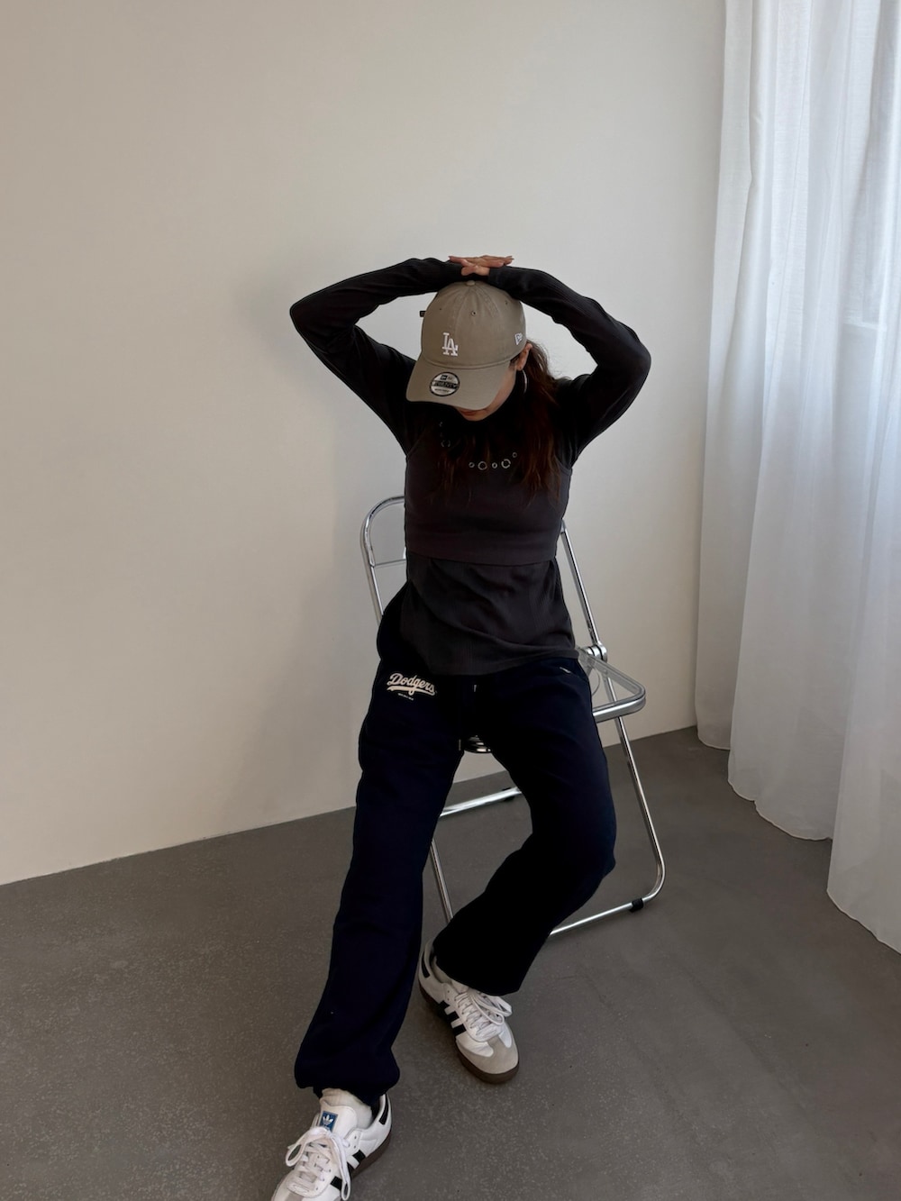 ブルー系のスウェットパンツ、グレー系のTシャツ/カットソー、ベージュ系のキャップを着用したレディースの冬コーディネートの2枚目の写真