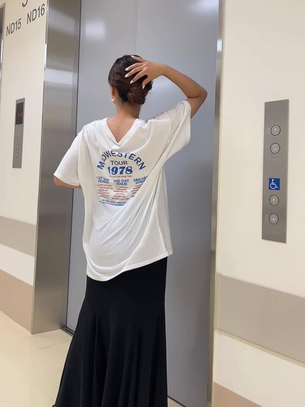 ブラック系のサンダル、ホワイト系のTシャツ/カットソー、ブラック系のスカートを着用したレディースの夏コーディネートの2枚目の写真