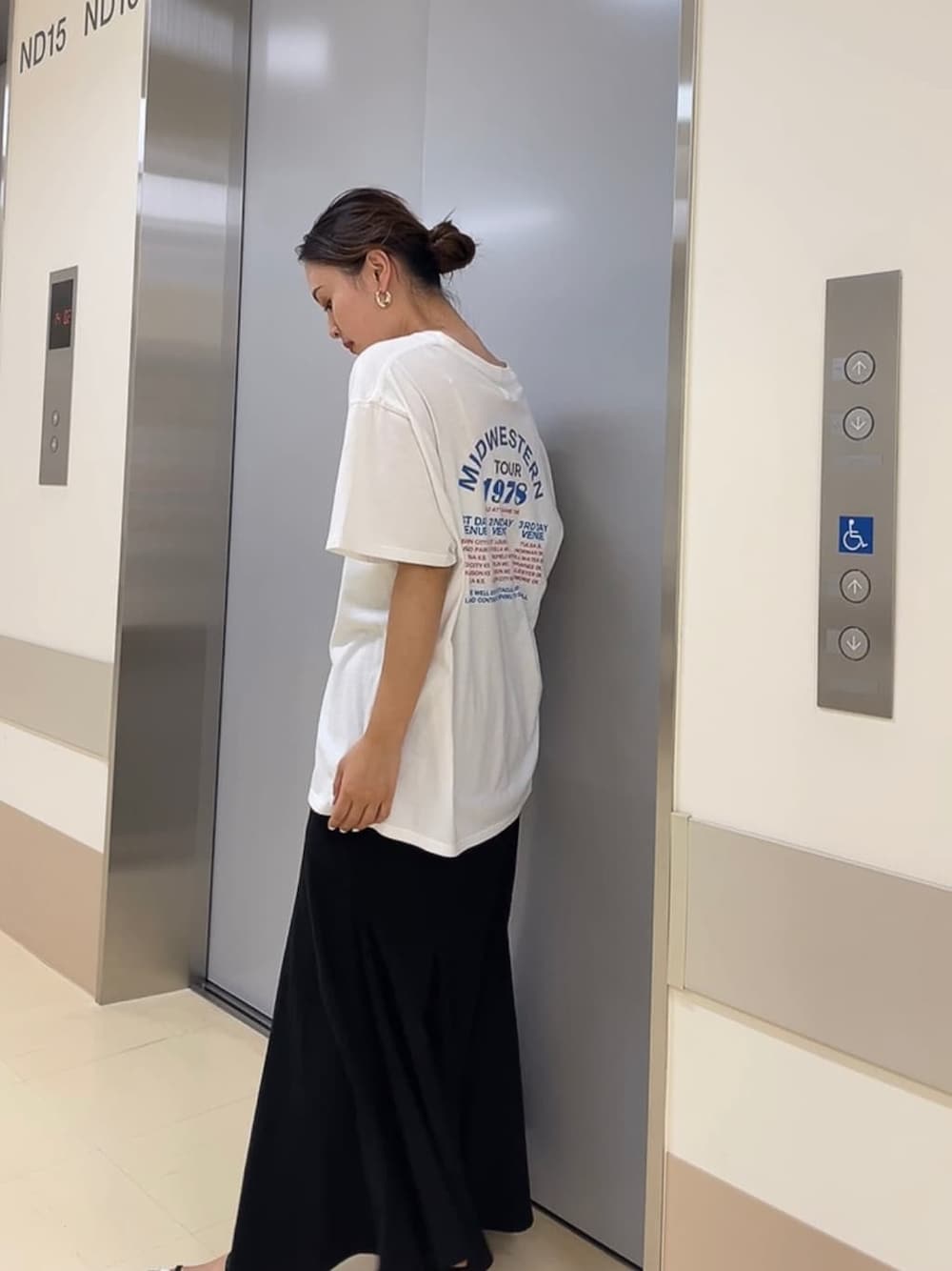 ブラック系のサンダル、ホワイト系のTシャツ/カットソー、ブラック系のスカートを着用したレディースの夏コーディネートの3枚目の写真