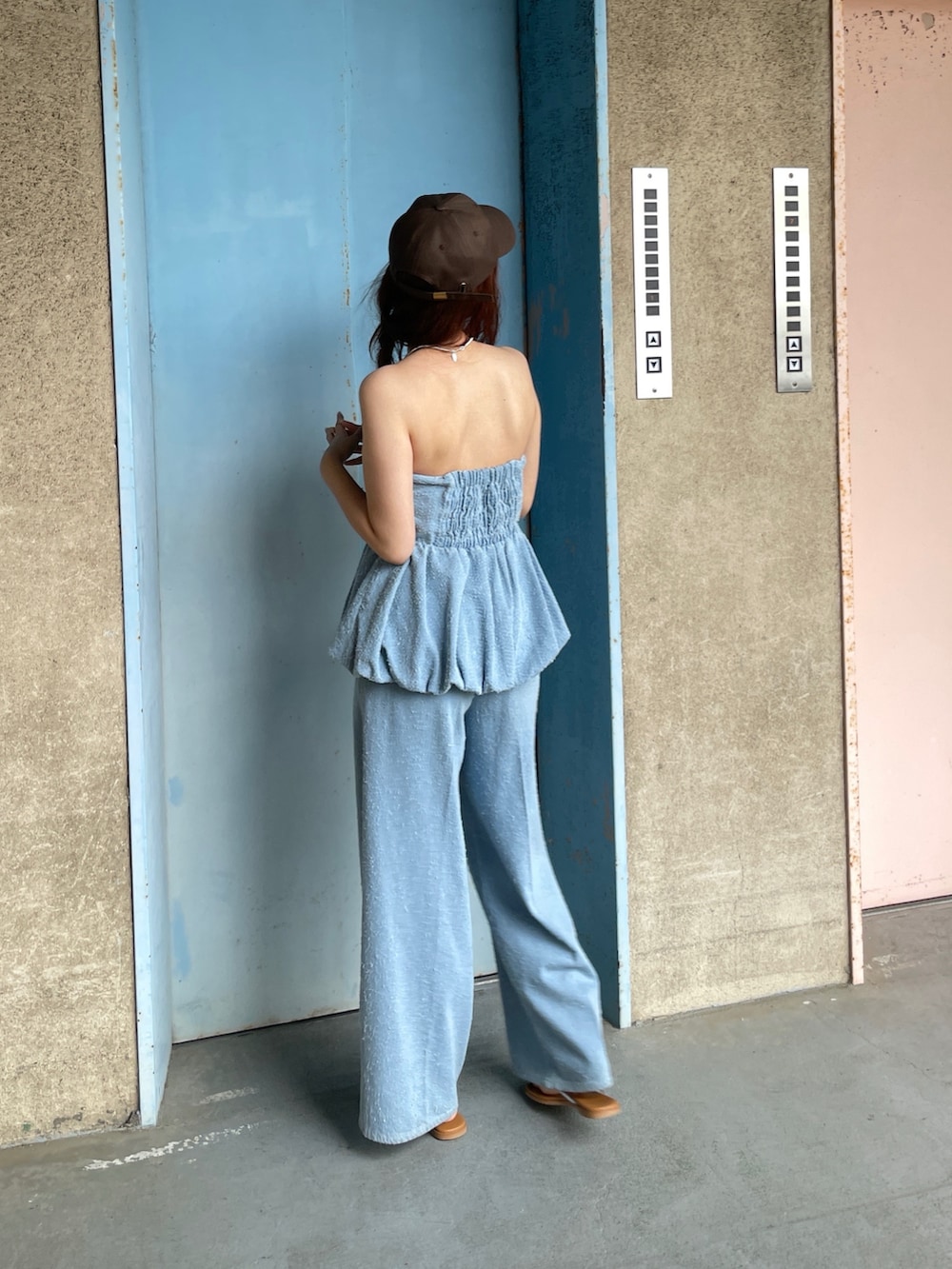 ブルー系のチューブトップ、ブルー系のデニムパンツを着用したレディースの春コーディネートの2枚目の写真