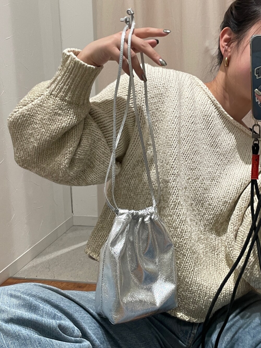 ホワイト系のニット/セーター、ブルー系のデニムパンツを着用したレディースの冬コーディネートの2枚目の写真