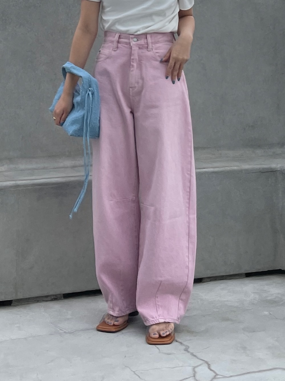 ピンク系のデニムパンツ、ブルー系のハンドバッグ、ホワイト系のTシャツ/カットソーを着用したレディースの春コーディネートの3枚目の写真
