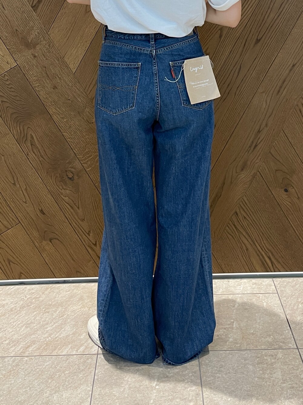 ブルー系のデニムパンツ、ホワイト系のスニーカー、グレー系のTシャツ/カットソーを着用したレディースの春コーディネートの7枚目の写真