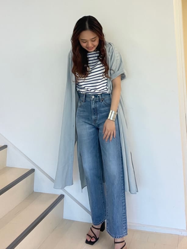 ブルー系のデニムパンツ、ブラック系のサンダル、ブルー系のシャツ/ブラウスを着用したレディースの夏コーディネートの6枚目の写真