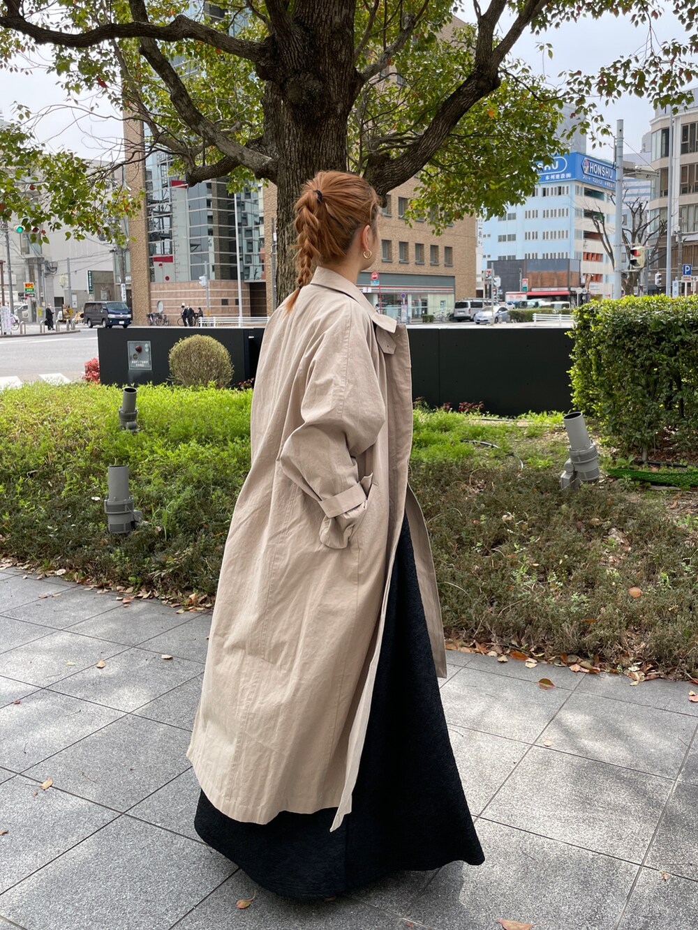 グリーン系のワンピース、ブルー系のトートバッグ、ベージュ系のステンカラーコートを着用したレディースの春コーディネートの6枚目の写真