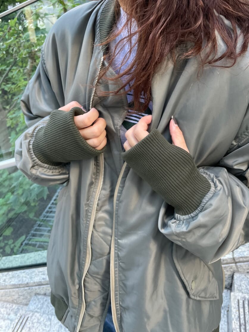 ブルー系のデニムパンツ、ブラック系のブーツ、グリーン系のMA-1を着用したレディースの秋コーディネートの8枚目の写真