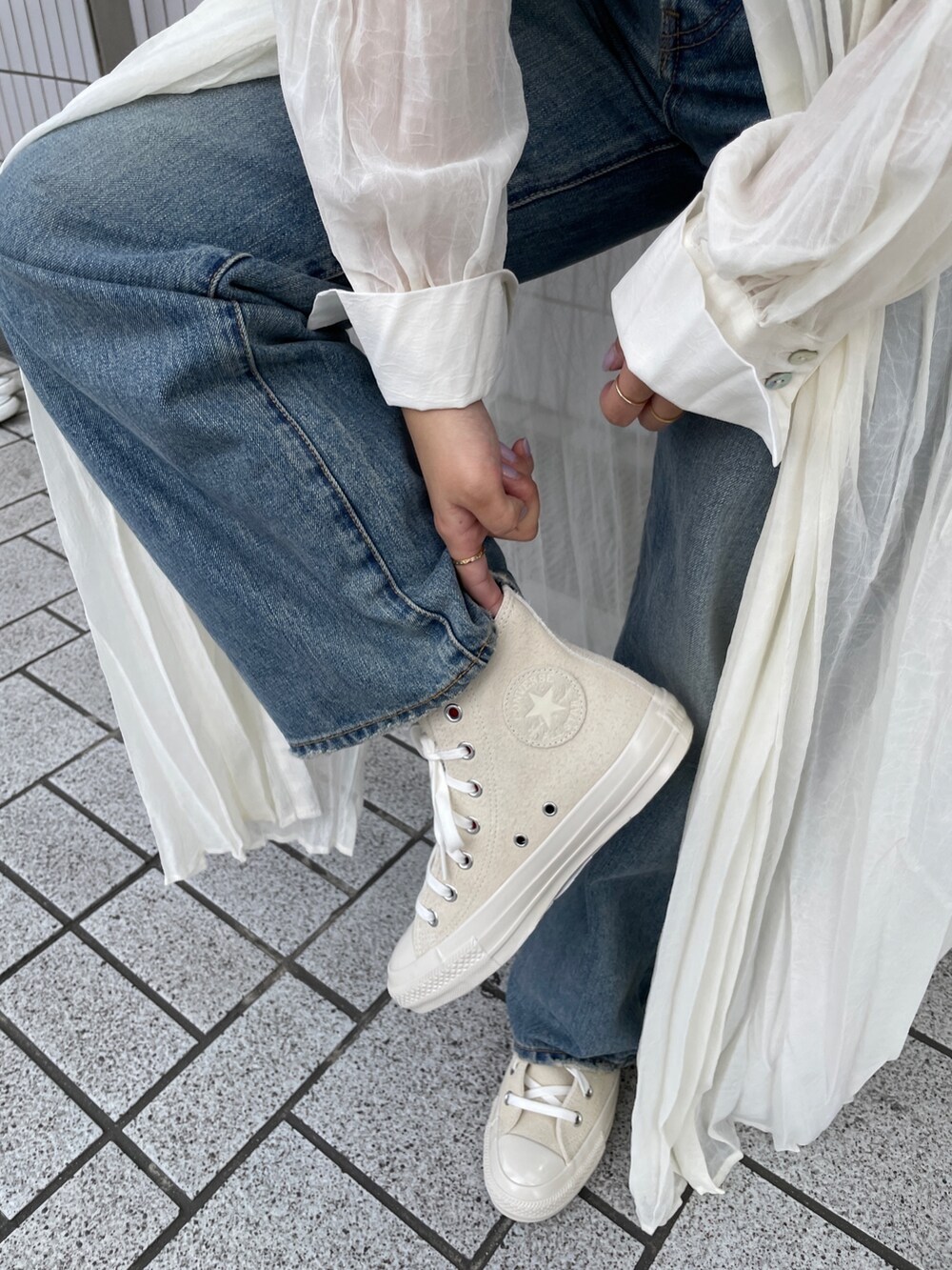 ブルー系のデニムパンツ、ホワイト系のスニーカー、ホワイト系のタンクトップを着用したレディースの春コーディネートの8枚目の写真