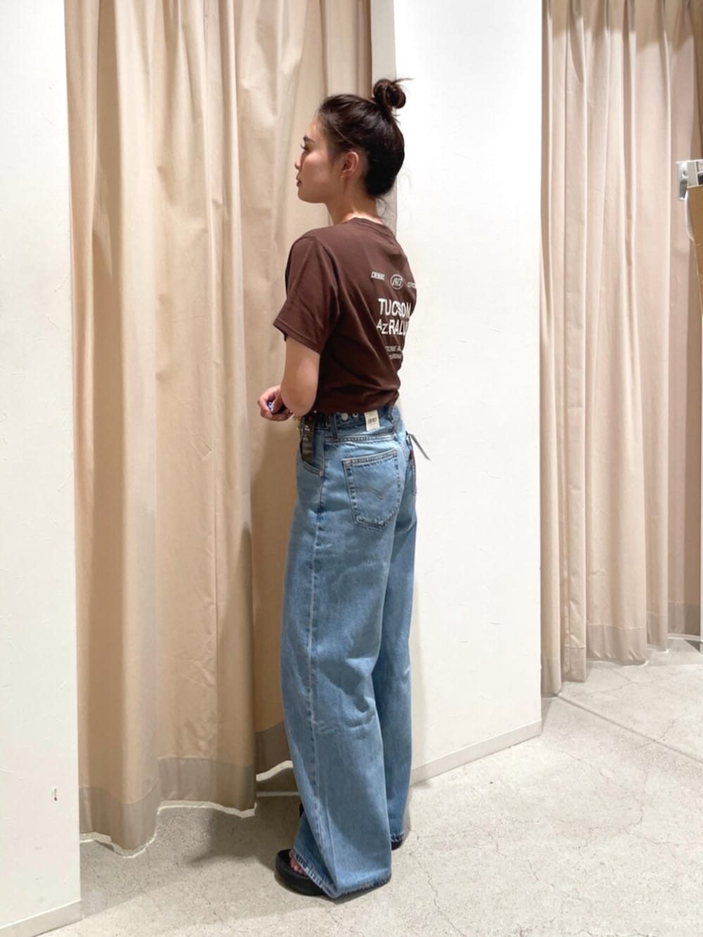 ブルー系のデニムパンツ、ブラウン系のTシャツ/カットソーを着用したレディースの夏コーディネートの2枚目の写真