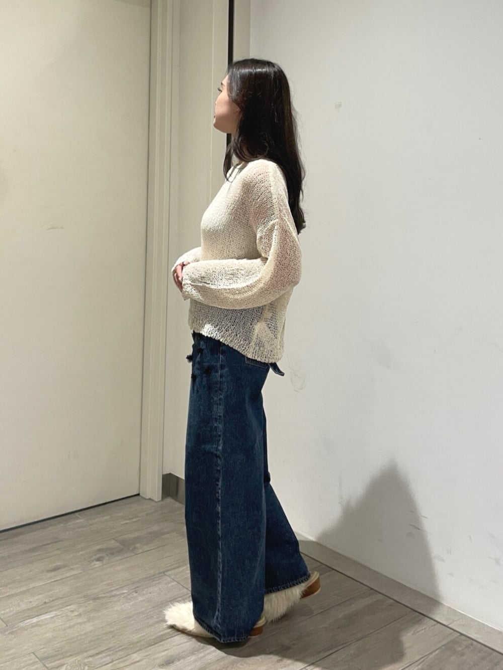 ホワイト系のニット/セーター、ホワイト系のその他シューズ、ブルー系のデニムパンツを着用したレディースの夏コーディネートの2枚目の写真