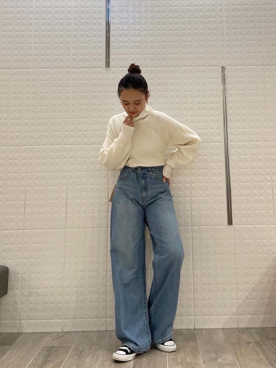 ブルー系のデニムパンツ、ホワイト系のTシャツ/カットソー、ホワイト系のワンピースを着用したレディースの秋コーディネートの6枚目の写真