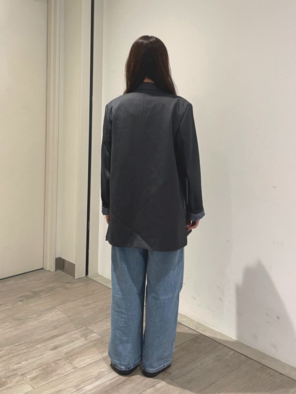 ブルー系のデニムパンツ、グレー系のテーラードジャケットを着用したレディースの夏コーディネートの3枚目の写真