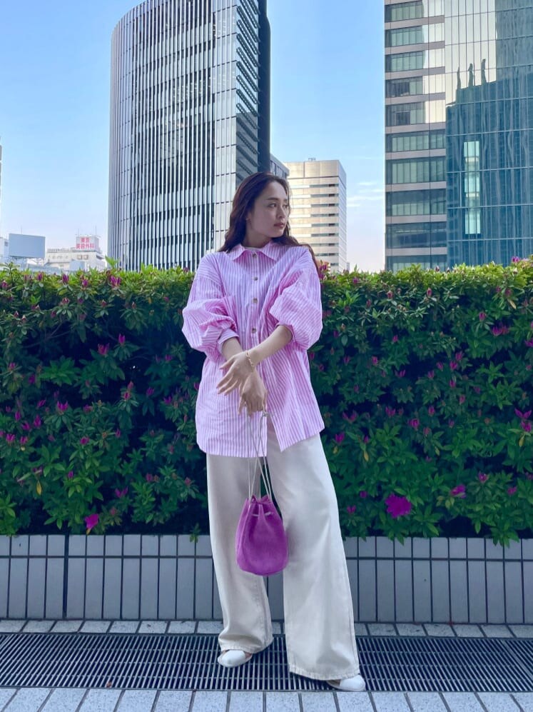 ピンク系のハンドバッグ、ピンク系のシャツ/ブラウス、ホワイト系のサンダルを着用したレディースの春コーディネートの4枚目の写真