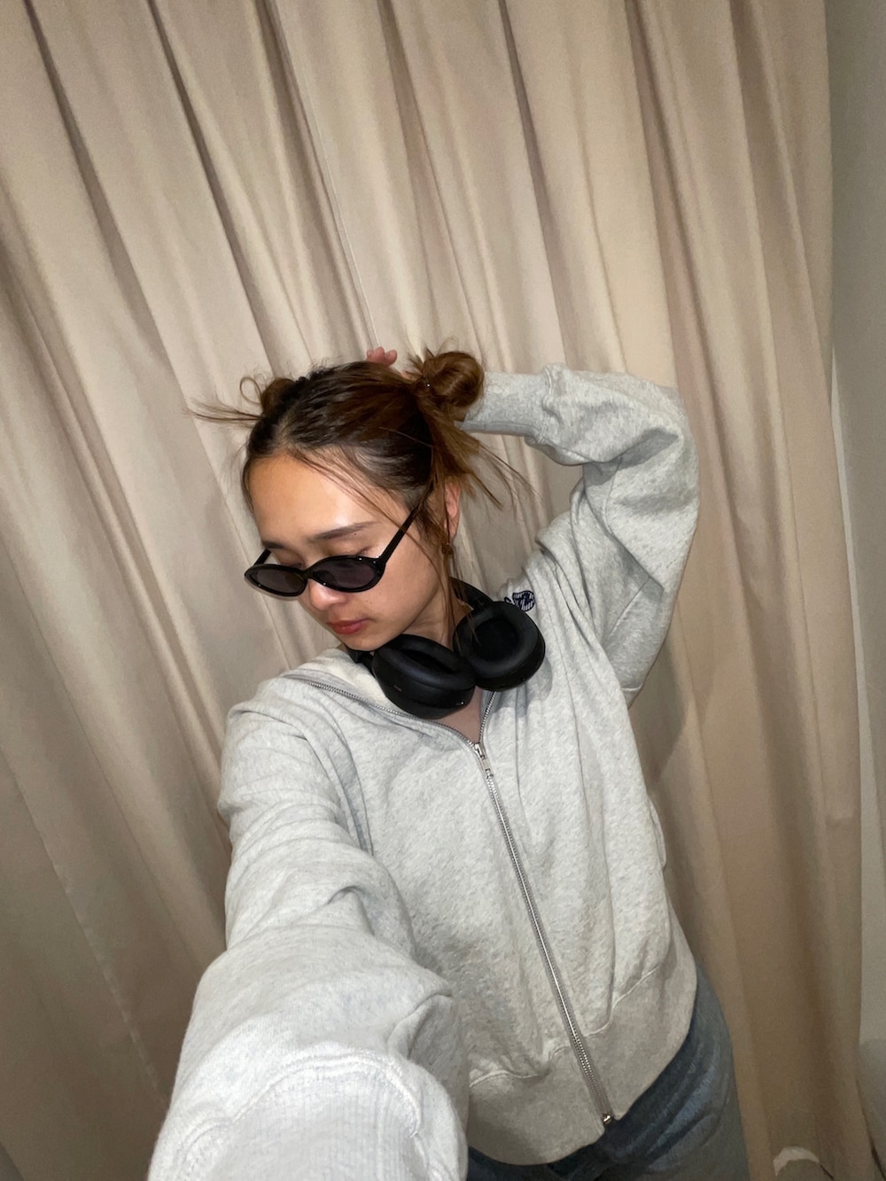 グレー系のパーカー、ブラック系のサングラスを着用したレディースの秋コーディネートの2枚目の写真