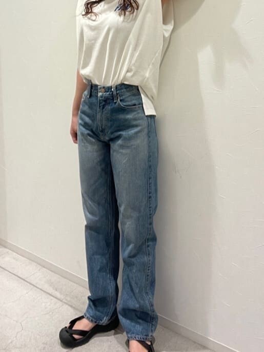 ホワイト系のタンクトップ、ブルー系のデニムパンツ、シルバー系のブレスレットを着用したレディースの春コーディネートの2枚目の写真