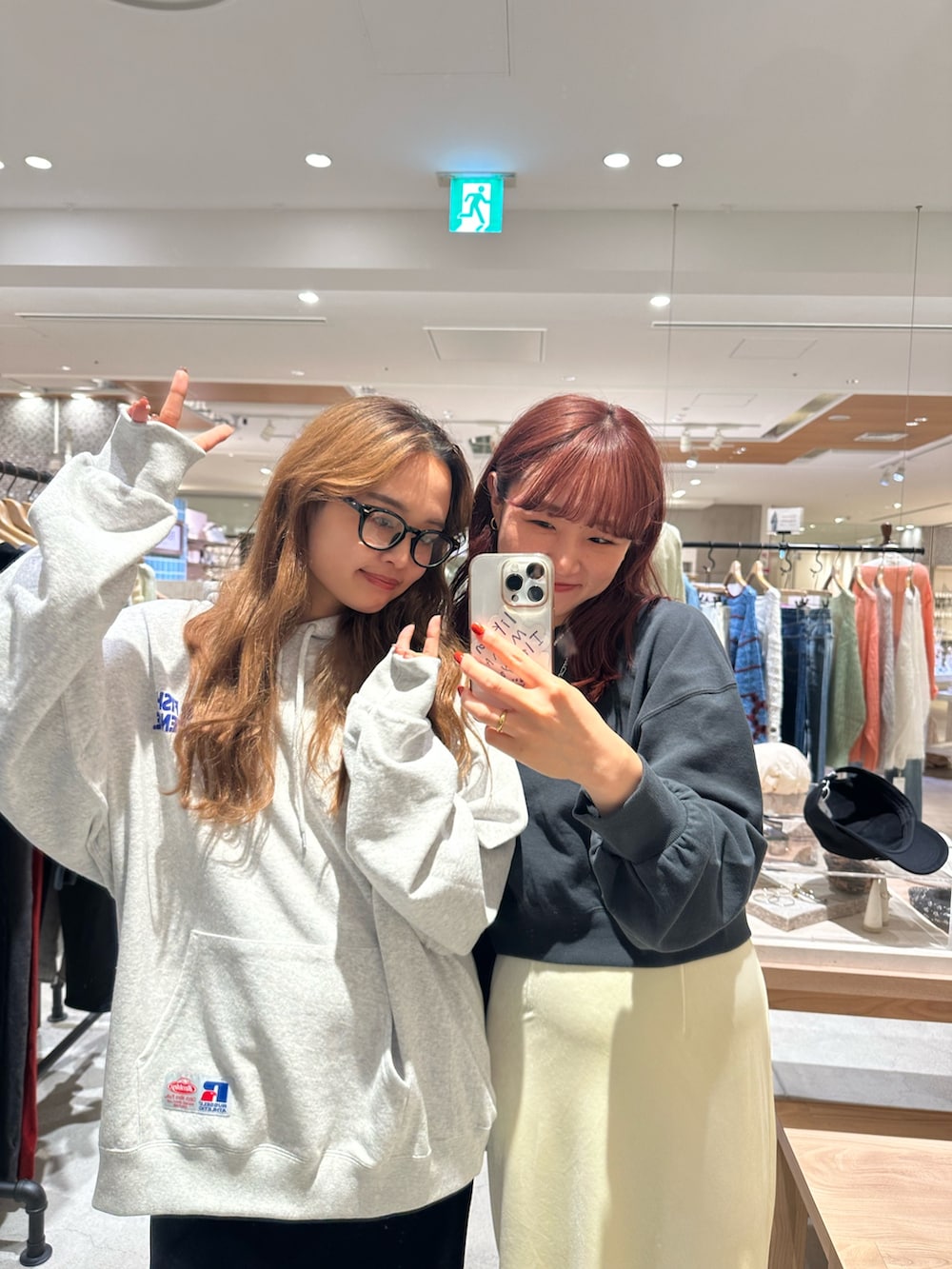 グレー系のパーカー、グレー系のスウェット、ブラック系のスカートを着用したレディースの秋コーディネートの2枚目の写真