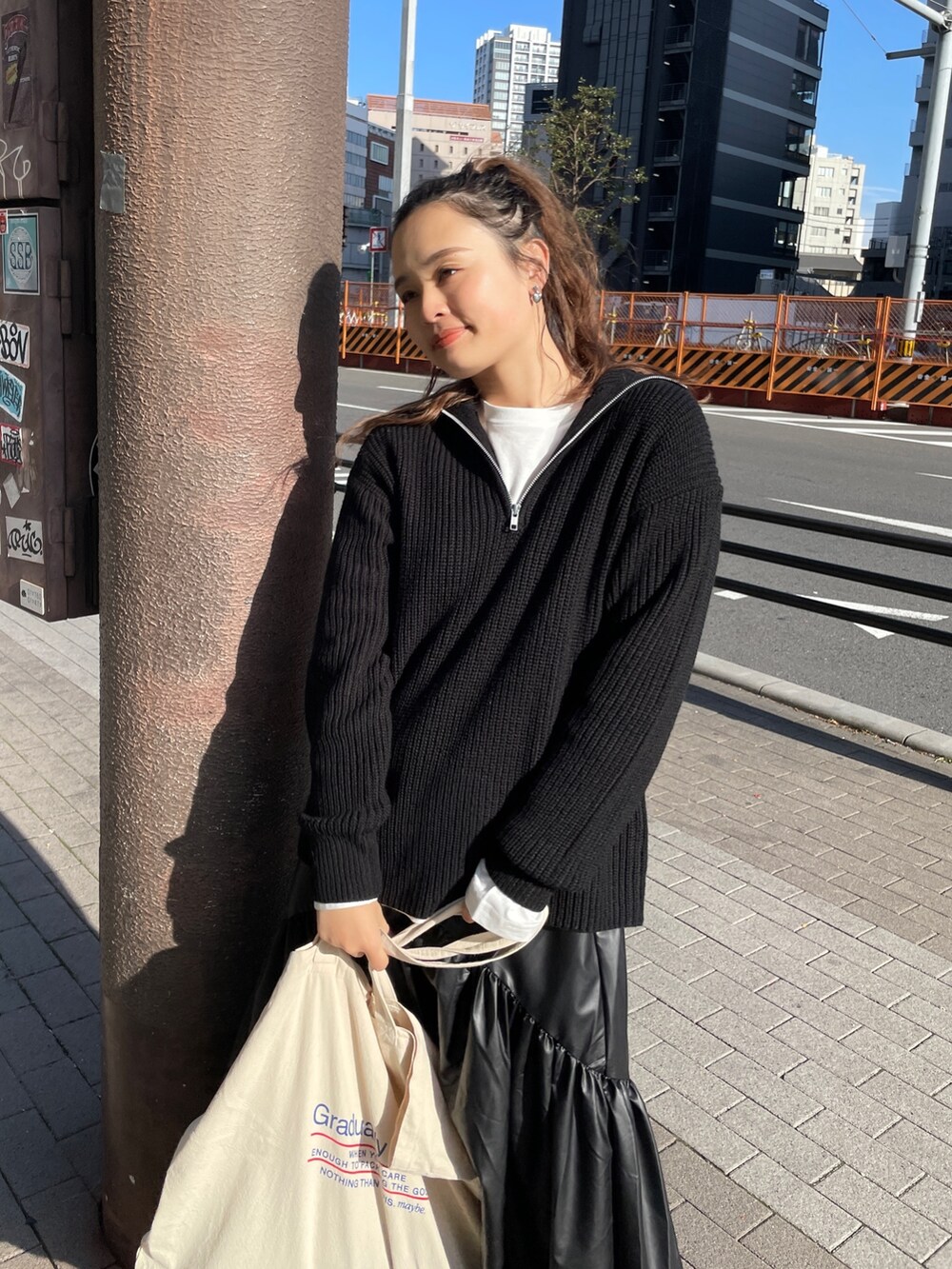 ブラック系のニット/セーター、ホワイト系のTシャツ/カットソー、ブラック系のスカートを着用したレディースの冬コーディネートの5枚目の写真