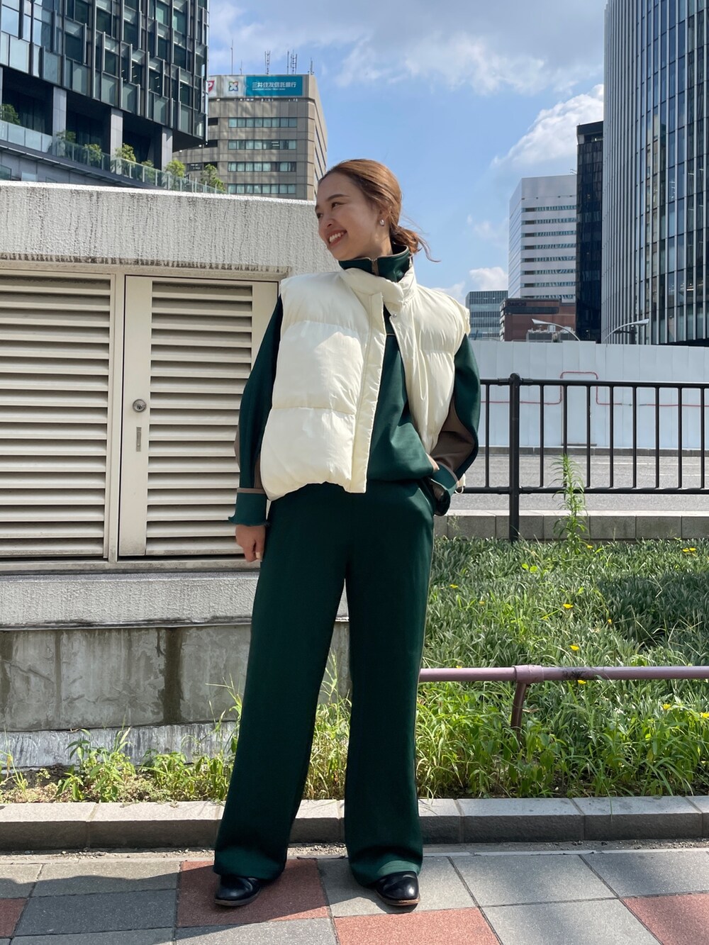 グリーン系のブルゾン、グリーン系のその他パンツ、ホワイト系のダウンベストを着用したレディースの秋コーディネートの6枚目の写真