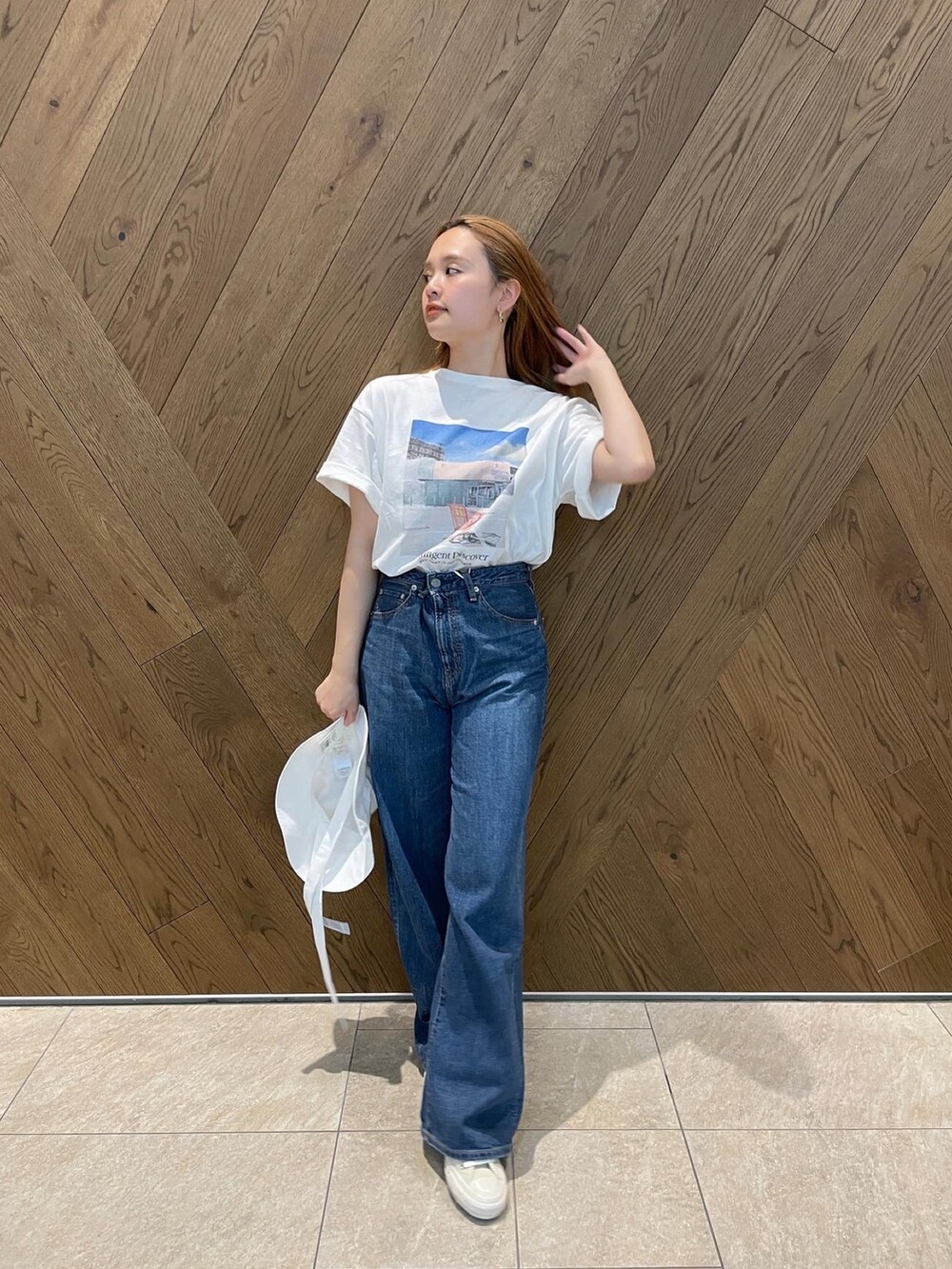 ブルー系のデニムパンツ、ホワイト系のスニーカー、グレー系のTシャツ/カットソーを着用したレディースの春コーディネートの2枚目の写真