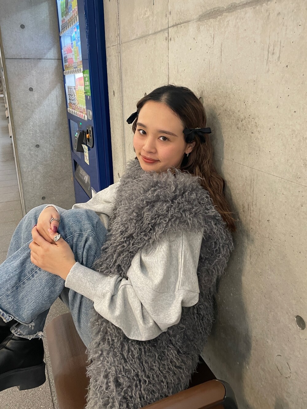 ブルー系のデニムパンツ、グレー系のスウェット、グレー系のベストを着用したレディースの冬コーディネートの2枚目の写真