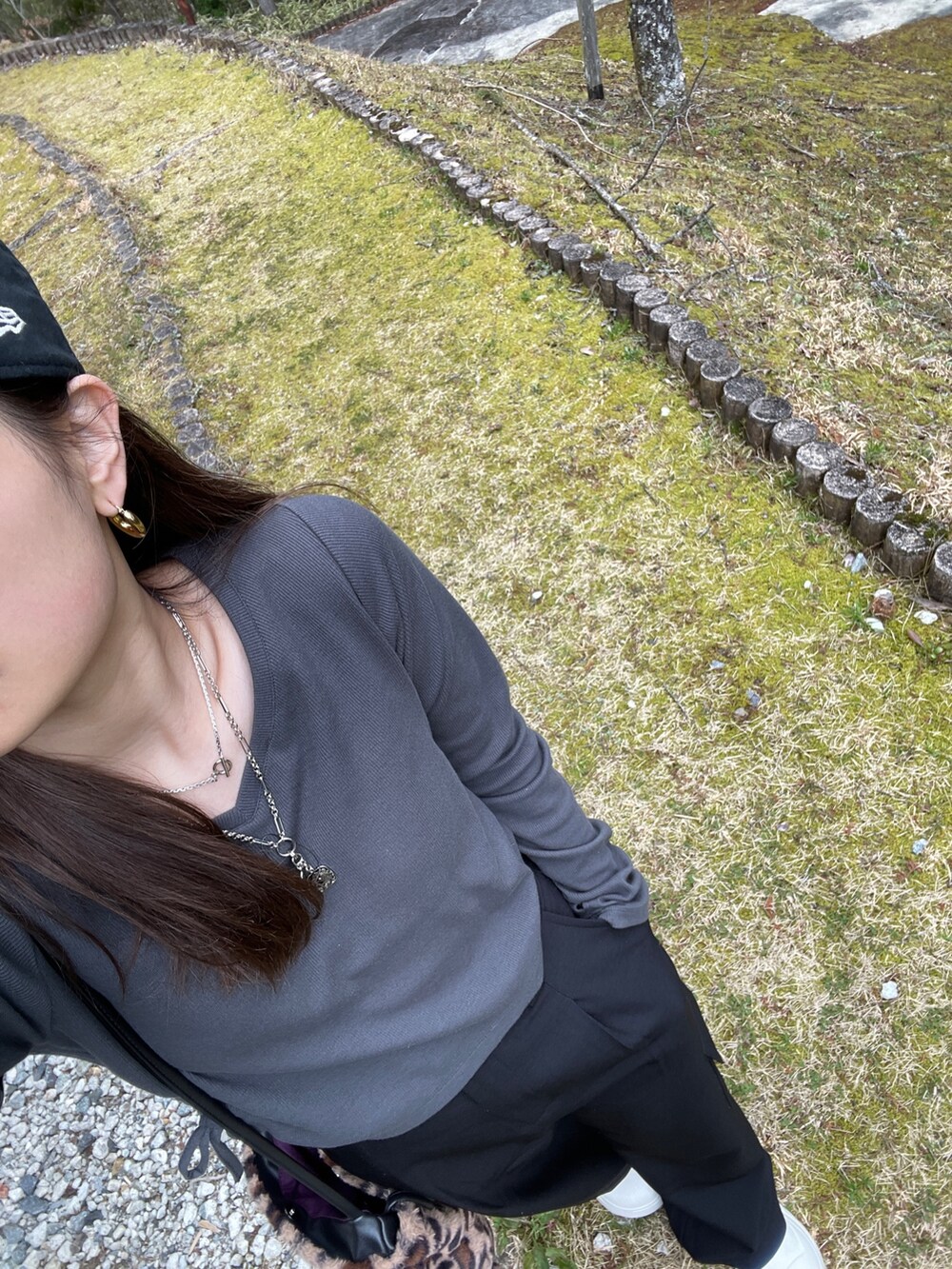 グレー系のTシャツ/カットソー、シルバー系のネックレス、ブラック系のキャップを着用したレディースの春コーディネートの2枚目の写真