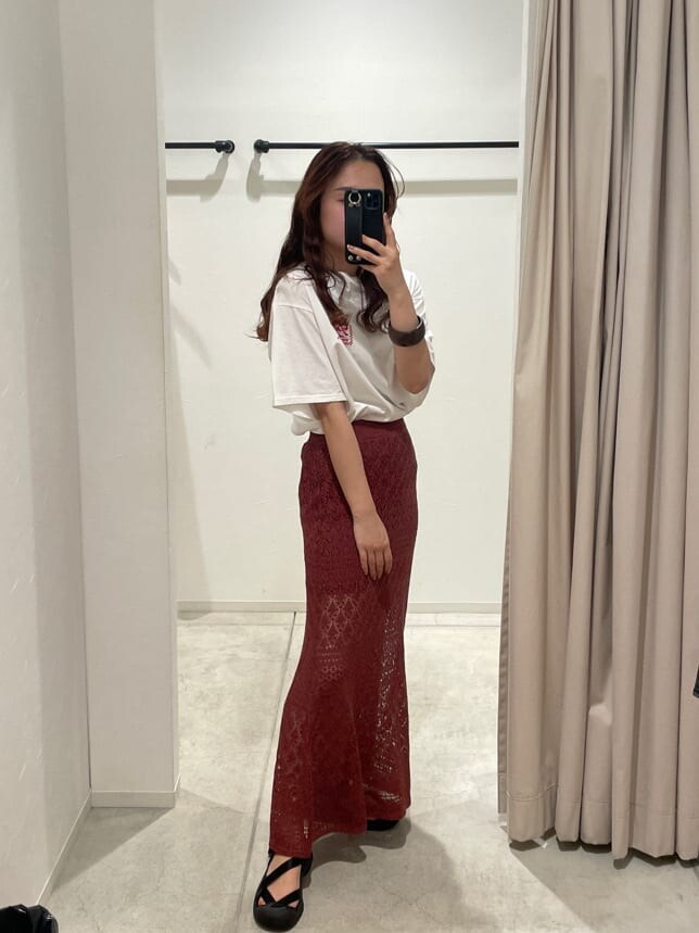 ホワイト系のTシャツ/カットソー、オレンジ系のスカート、ブラウン系のブレスレットを着用したレディースの春コーディネートの7枚目の写真