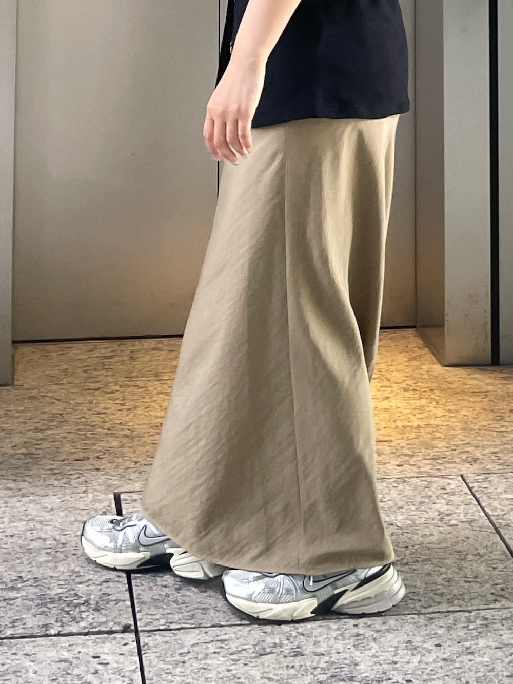 ブラック系のカーディガン/ボレロ、ベージュ系のスカートを着用したレディースの夏コーディネートの5枚目の写真