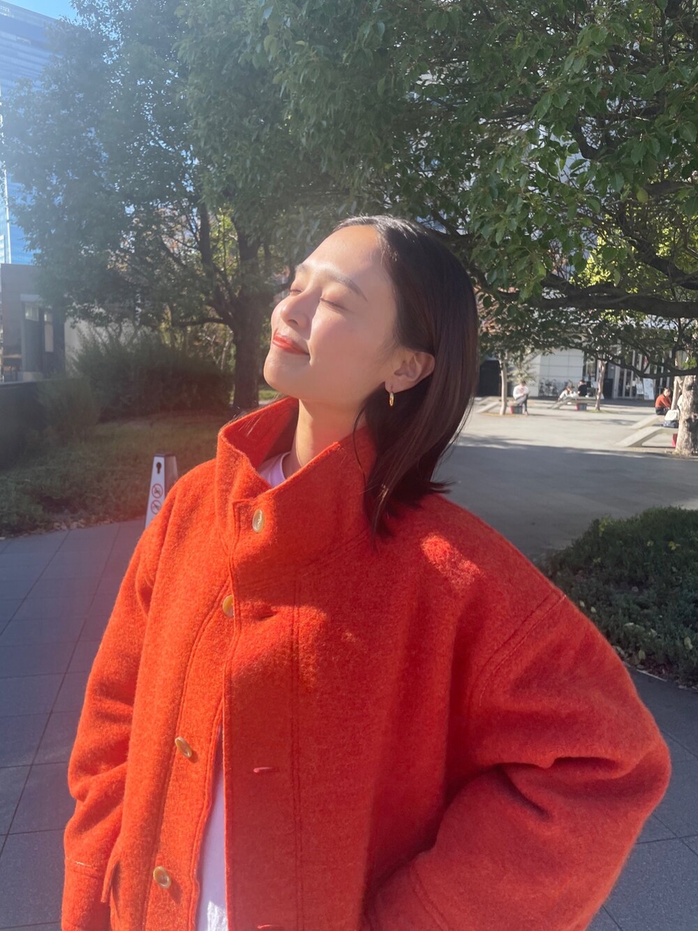 ホワイト系のTシャツ/カットソー、オレンジ系のブルゾン、ブルー系のデニムパンツを着用したレディースの秋コーディネートの7枚目の写真