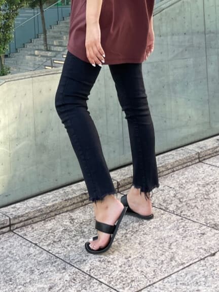 ブラック系のデニムパンツ、ブラック系のサンダル、ブラウン系のTシャツ/カットソーを着用したレディースの夏コーディネートの6枚目の写真