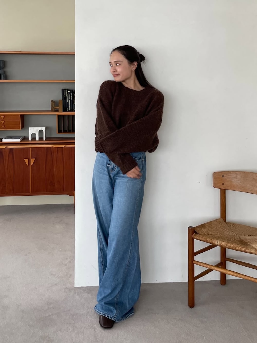 ブルー系のデニムパンツ、ブラウン系のニット/セーターを着用したレディースの夏コーディネートの2枚目の写真