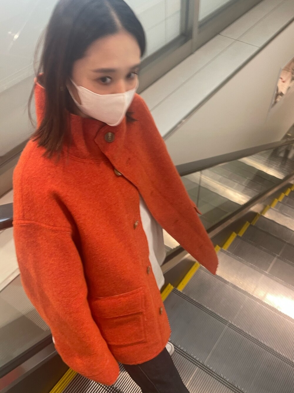 ホワイト系のTシャツ/カットソー、オレンジ系のブルゾン、ブルー系のデニムパンツを着用したレディースの秋コーディネートの3枚目の写真