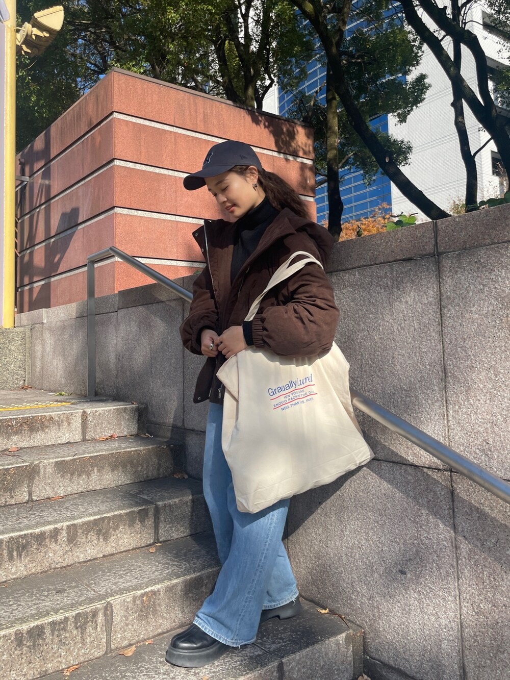 ブルー系のデニムパンツ、ブラウン系のブルゾン、ブラック系のニット/セーターを着用したレディースの冬コーディネートの5枚目の写真