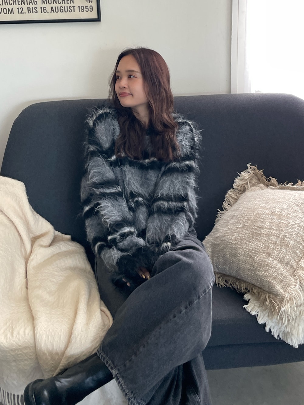 ブラック系のニット/セーター、ブラック系のデニムパンツを着用したレディースの秋コーディネートの2枚目の写真